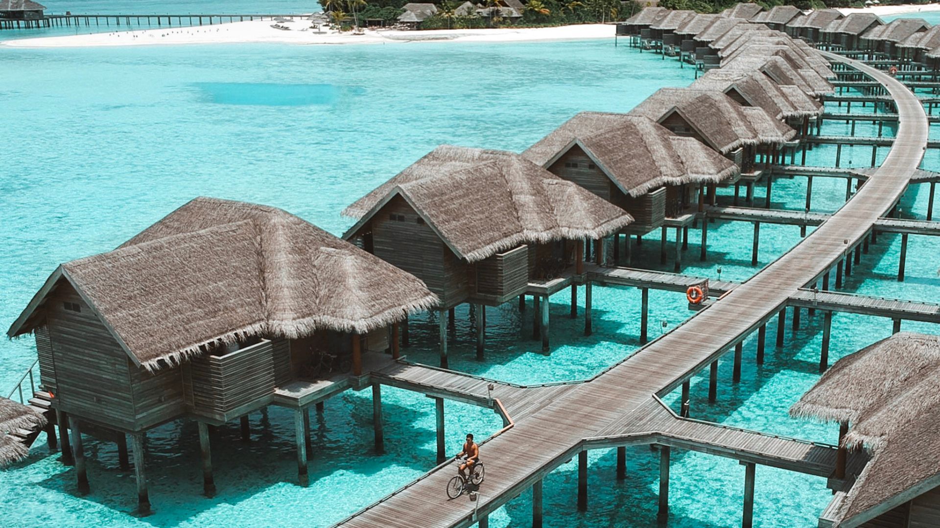 A boy cycling in luxury water villas of Vakkaru Maldives