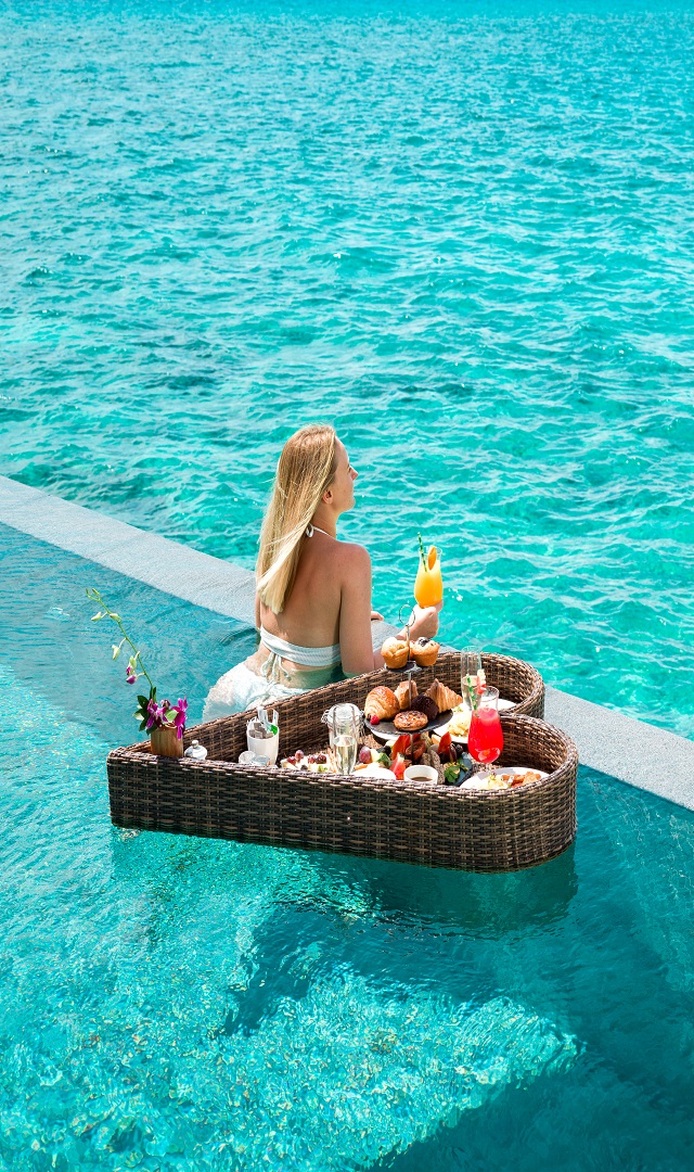 A women drinking fresh juice with floating breakfast at Maldives