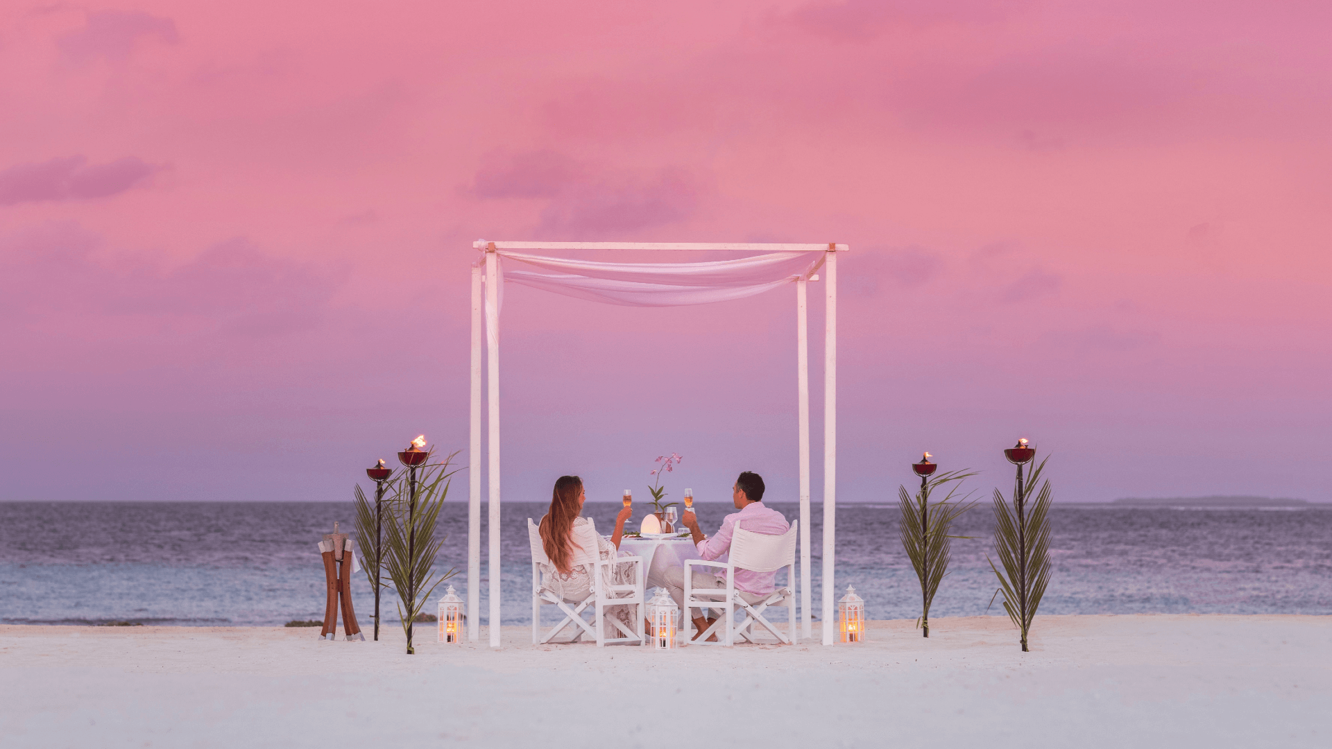 Romantic decorated dining set up on white sand beach at Maldives